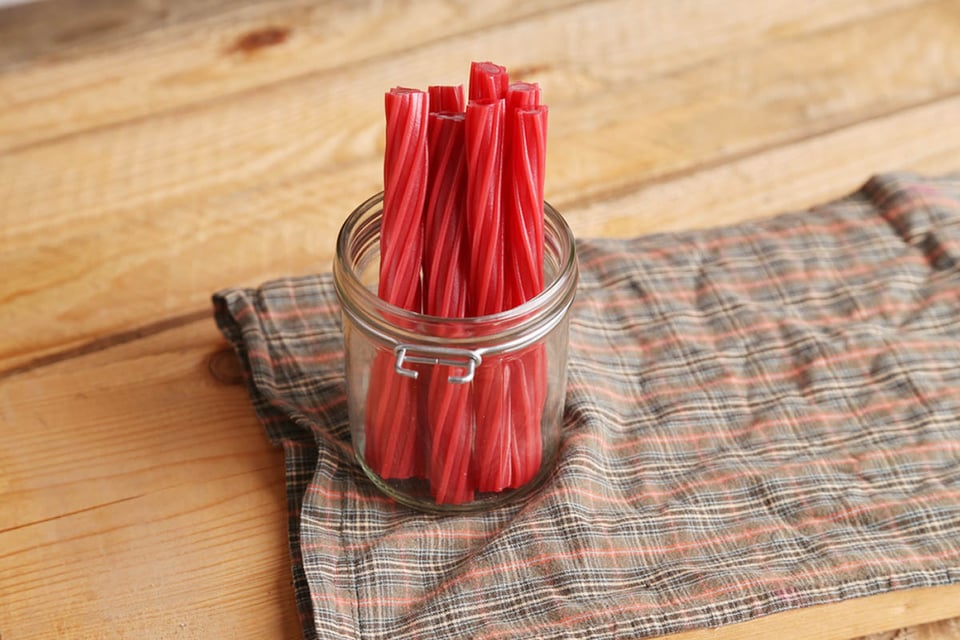 twizzlers, palitos de regaliz, frasco con palitos de dulce, mesa, MundoNOW