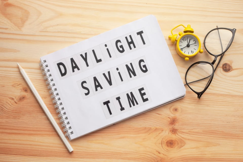 Daylight saving time, notepad, retro alarm clock, wooden table