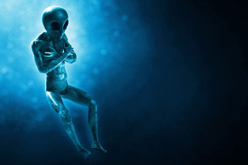 Alienígena abrazándose a sí mismo flotando