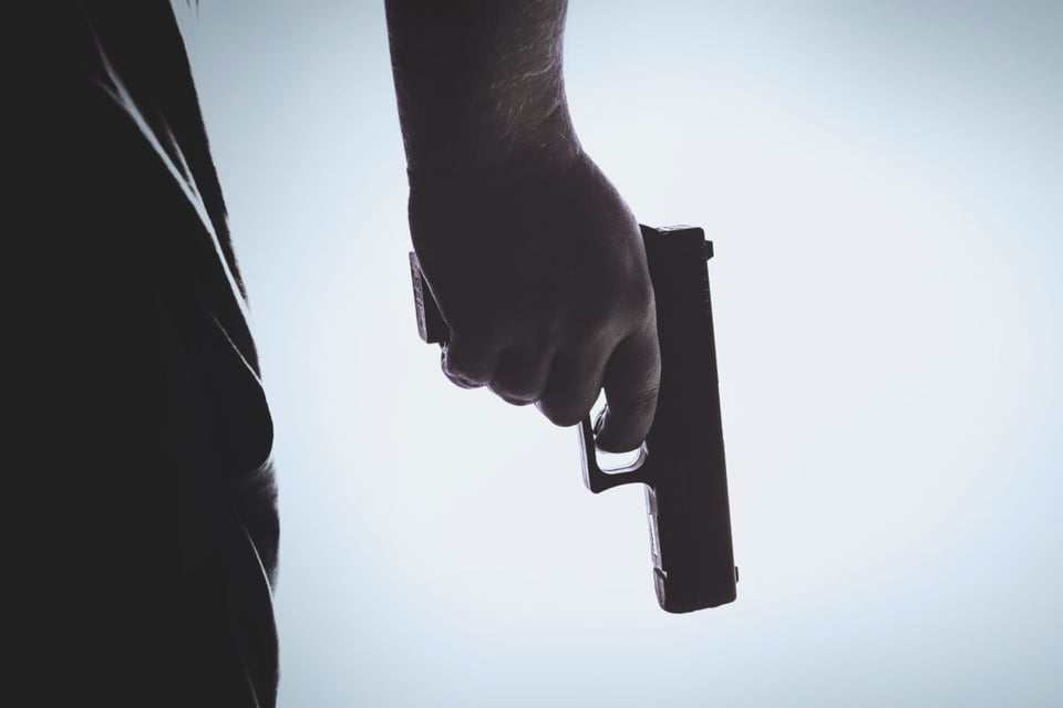 La mano de un sicario sosteniendo una pistola