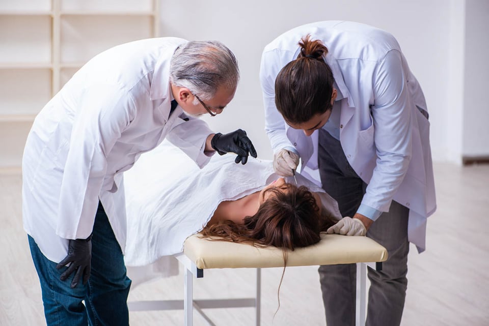 coroner examining dead body, corpse, morgue