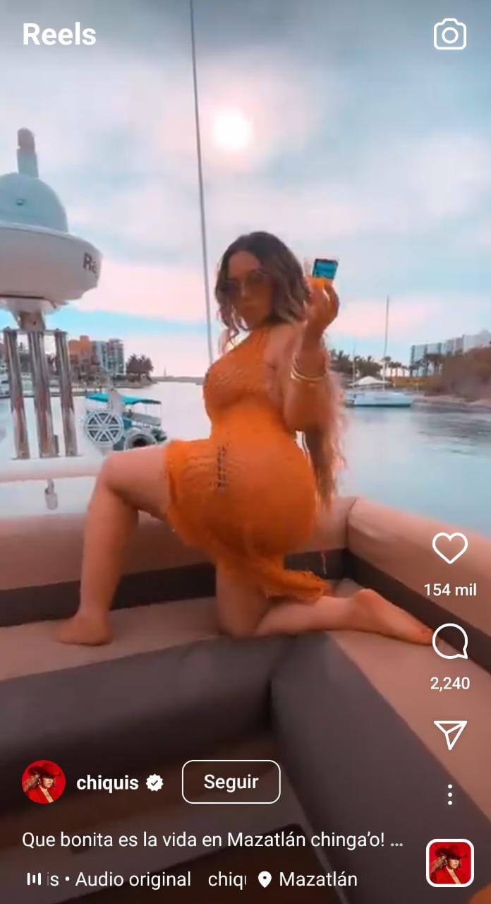 Chiquis Rivera dances in an orange pareo by the sea