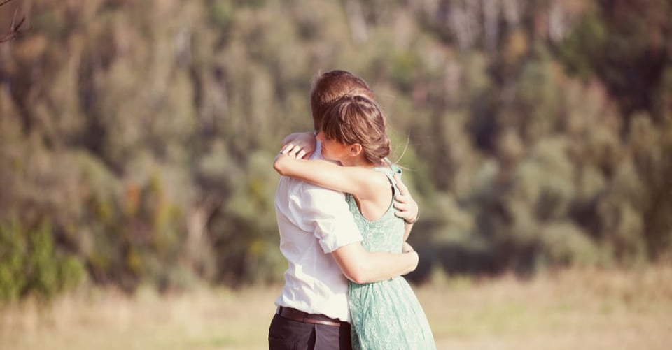 A couple hugging while filming them for a telenovela