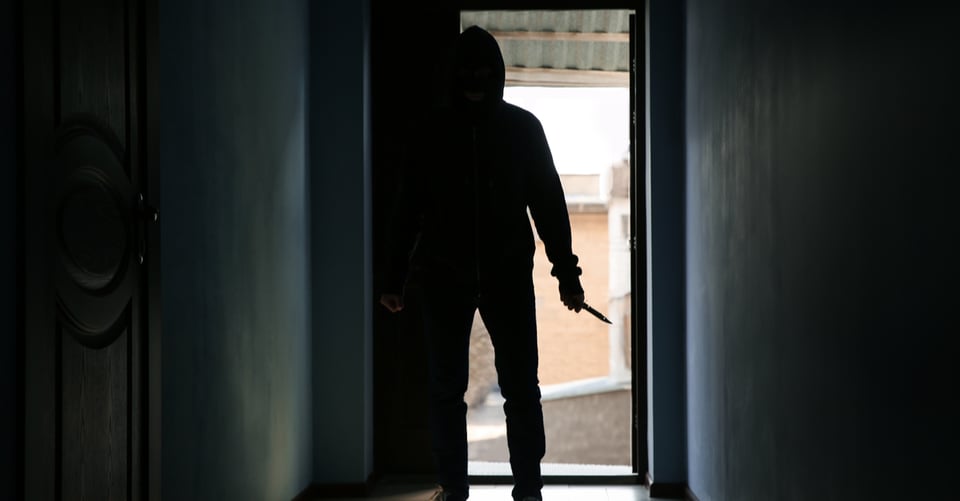 Silhouette of a murderer entering a house